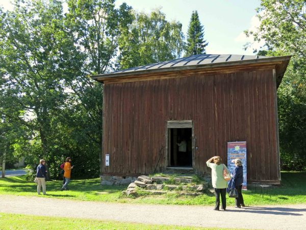 Puumakasiini, jonka ovi on auki ja edustalla on joitakin ihmisiä sekä roll-up -mainosteline.